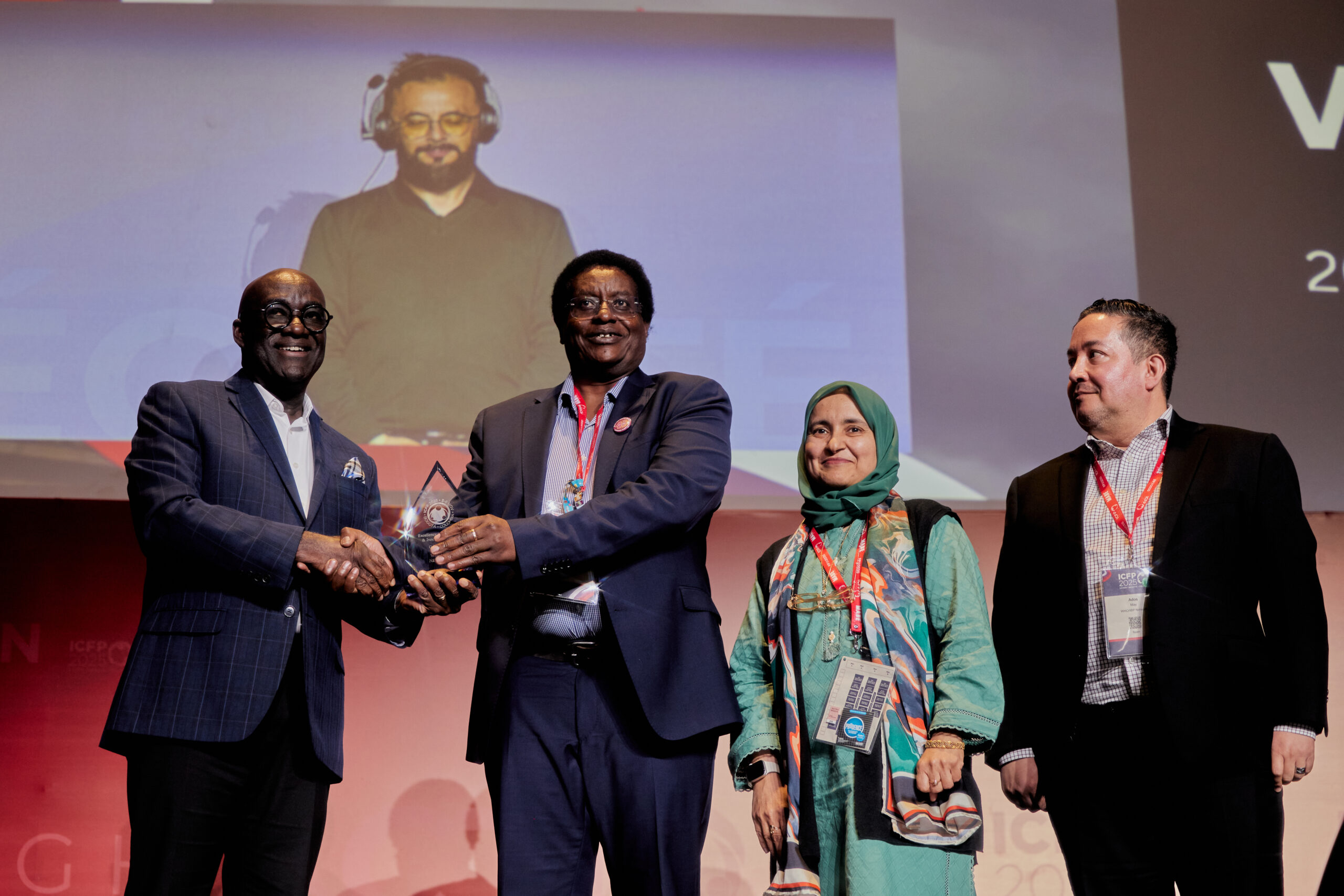 Trois personnes recevant un prix sur scène