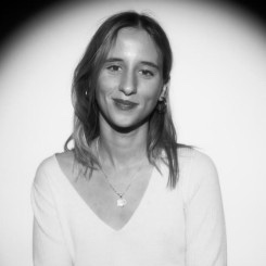 Portrait d'une femme vêtue d'un blazer marron sur fond noir